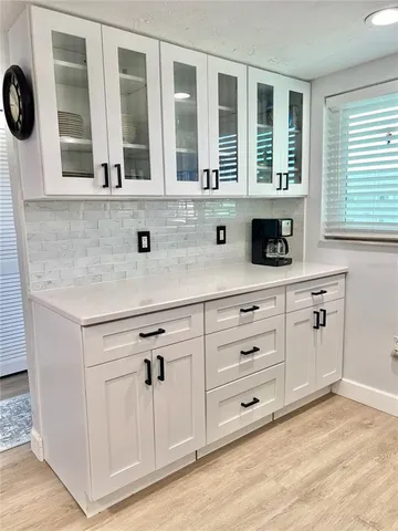 a kitchen with stainless steel appliances granite countertop a sink window and cabinets