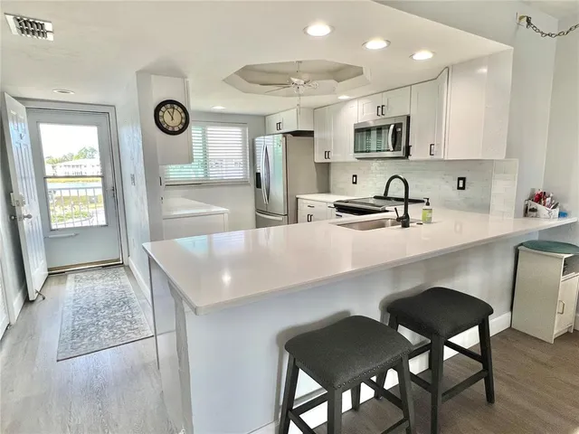 a kitchen with cabinets table and chairs