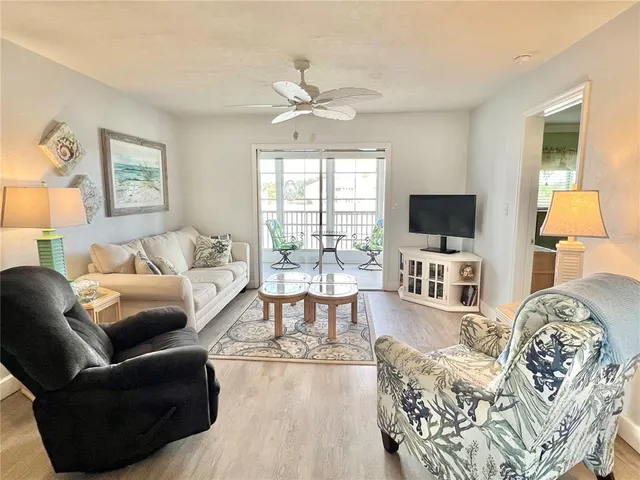 a living room with furniture a flat screen tv and a floor to ceiling window