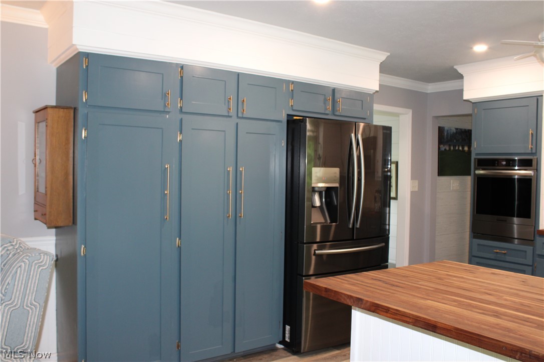 5547 River Styx Road Medina, OH 44256 - Photo 12 of 45 Kitchen featuring floor-to-ceiling blue cabinetry with gold-tone hardware, a stainless steel French door refrigerator, a built-in oven, and a butcher block countertop