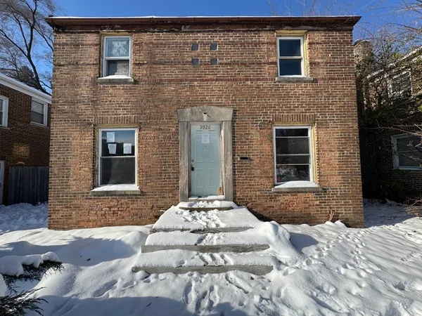 a brick house with a yard in front of it