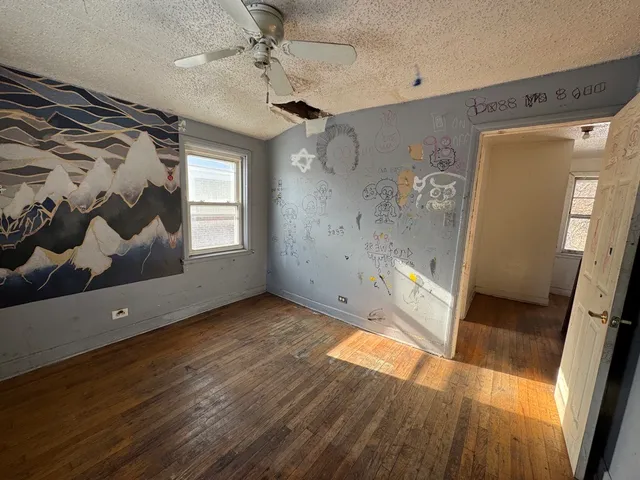 a view of a room with wooden floor and white walls