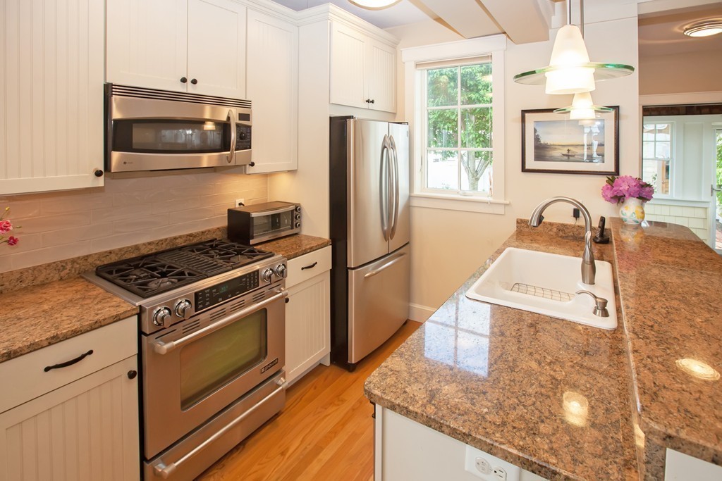 129 Fort Point Road Weymouth, MA 02191 - Photo 8 of 30 a kitchen with stainless steel appliances granite countertop a stove a microwave and a refrigerator