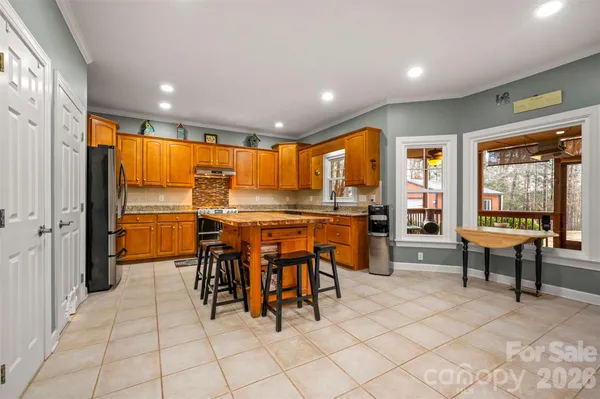 a dining hall with stainless steel appliances a dining table chairs and view of living room