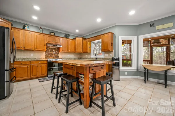 a kitchen with stainless steel appliances kitchen island granite countertop a sink and cabinets
