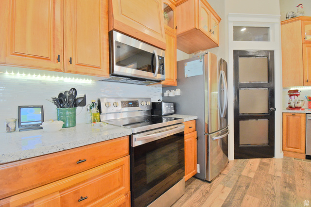 656 South Bullion Canyon Road Marysvale, UT 84750 - Photo 12 of 57 Kitchen with stainless steel appliances, glass insert cabinets, light stone countertops, light wood finished floors, and decorative backsplash