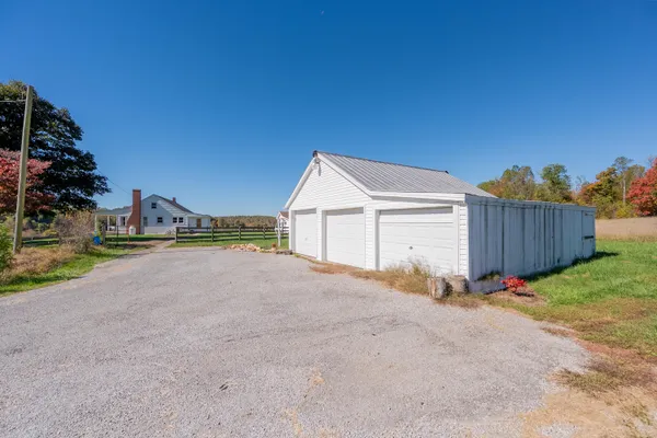 a view of backyard of house and car parked