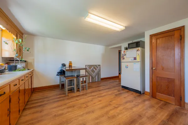 a view of a hallway with wooden floor and a bathroom
