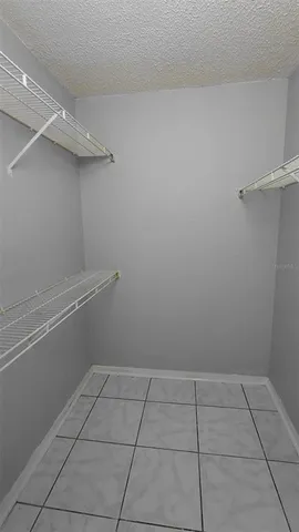 an empty room with closet and a chandelier fan