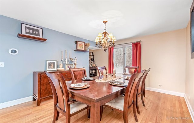 6914 Red Barn Road Crystal Lake, IL 60012 - Photo 23 of 63 a view of a dining room with furniture wooden floor and chandelier