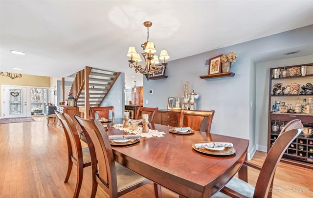 6914 Red Barn Road Crystal Lake, IL 60012 - Photo 24 of 63 a dining room with furniture a chandelier and wooden floor