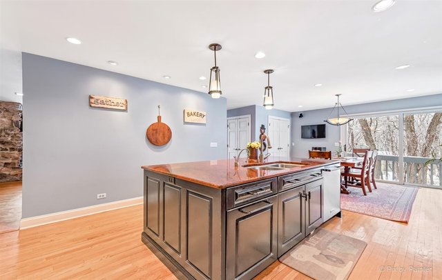 6914 Red Barn Road Crystal Lake, IL 60012 - Photo 26 of 63 a kitchen with stainless steel appliances granite countertop a stove and a view of living room