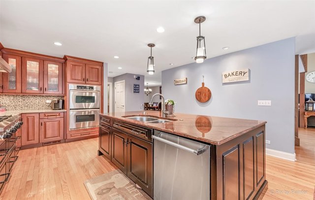 6914 Red Barn Road Crystal Lake, IL 60012 - Photo 27 of 63 a kitchen with stainless steel appliances granite countertop a sink a stove and a wooden floors