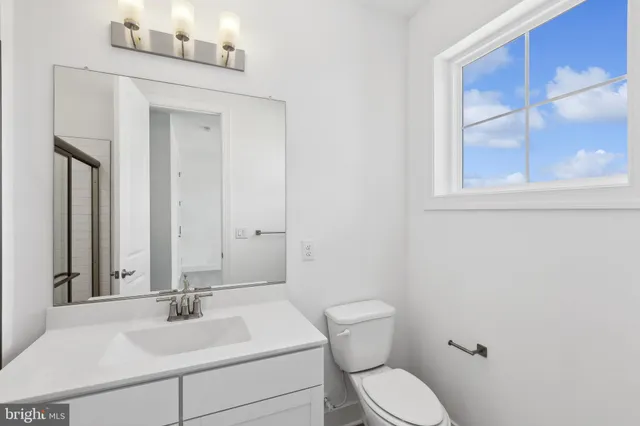 a bathroom with a toilet a sink and mirror