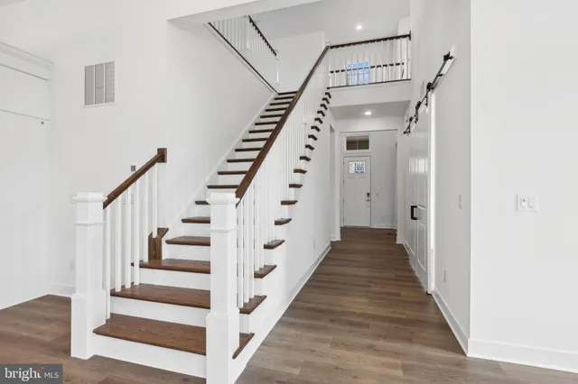 a view of a hallway with wooden floor and staircase