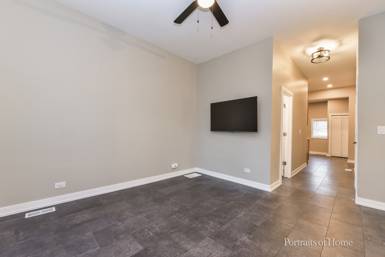 3501 West Le Moyne Street, Unit 1 Chicago, IL 60651 - Photo 5 of 27 an empty room with chandelier fan and windows