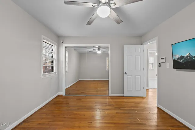 an empty room with closet and a chandelier fan
