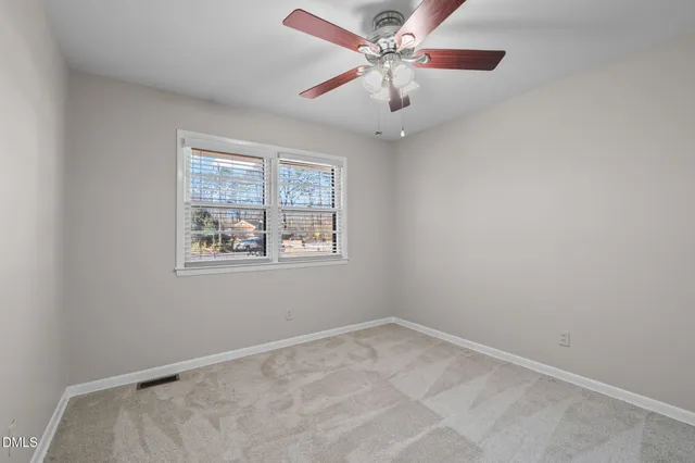 a view of an empty room with a fireplace and a window