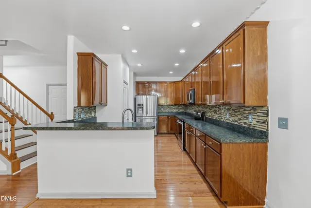 a kitchen with stainless steel appliances granite countertop a stove a sink and a microwave