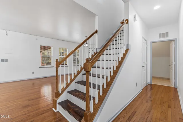 a view of staircase with wooden floor and white walls