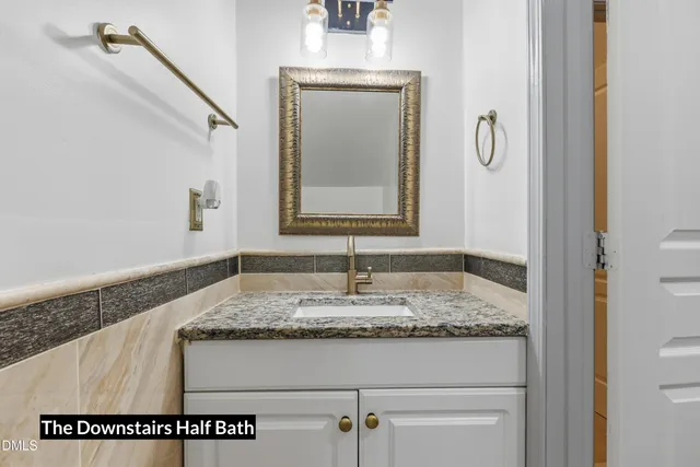 a bathroom with a granite countertop sink and a mirror