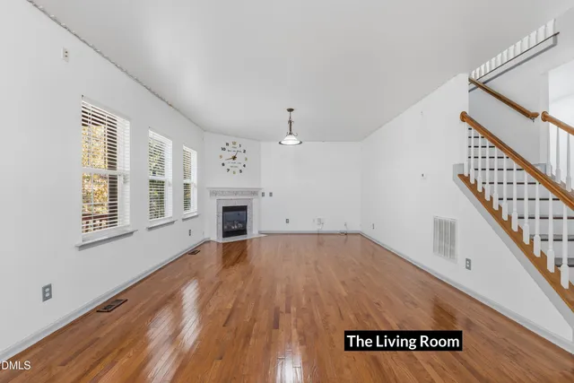 a view of empty room with wooden floor and fireplace
