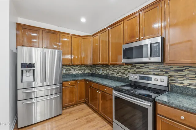 a kitchen with stainless steel appliances granite countertop a refrigerator microwave and sink