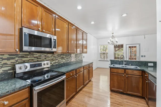 a kitchen with stainless steel appliances wooden cabinets and a stove top oven