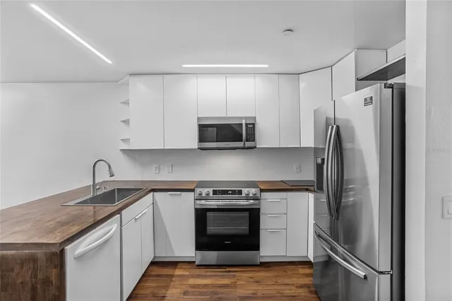 a view of kitchen with granite countertop cabinets and refrigerator