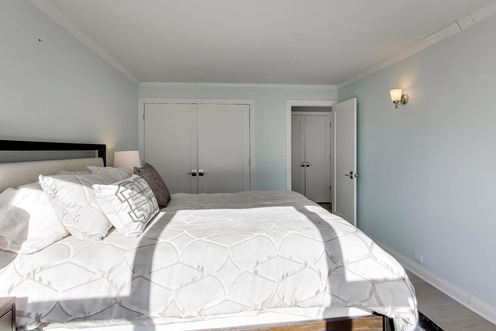 40 East Cedar Street, Unit 18B Chicago, IL 60611 - Photo 15 of 24 a bedroom with a bed and a mirror