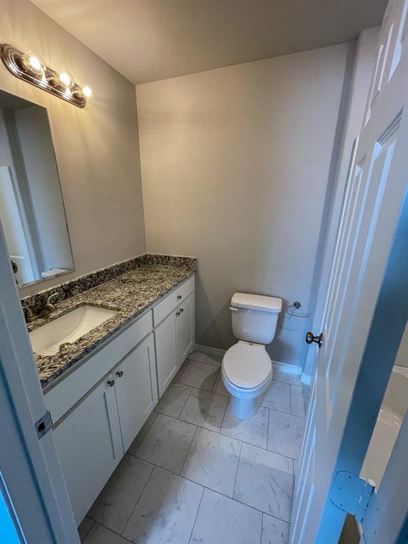 2740 Ginger Court Sherman, TX 75092 - Photo 7 of 16 a bathroom with a granite countertop toilet and a sink