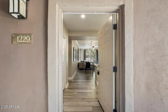 a view of a hallway with wooden floor and a bathroom