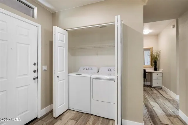 a view of utility room with closet and wooden floor