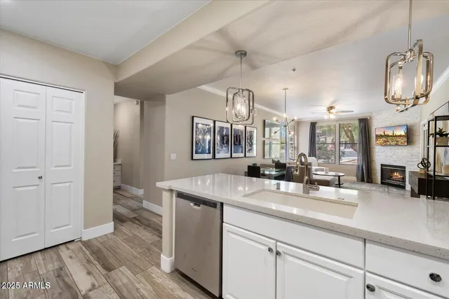 a hall with kitchen island granite countertop a sink and a wooden floor