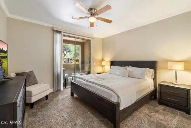 a large bed sitting in a bedroom next to a window with a chandelier and a couch