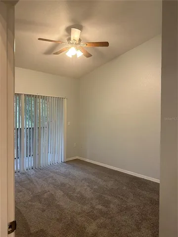 an empty room with a chandelier fan