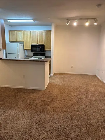 a kitchen with granite countertop a stove a sink and a microwave