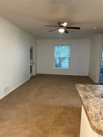 an empty room with a chandelier fan