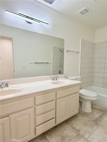 a bathroom with a double vanity sink toilet and a mirror
