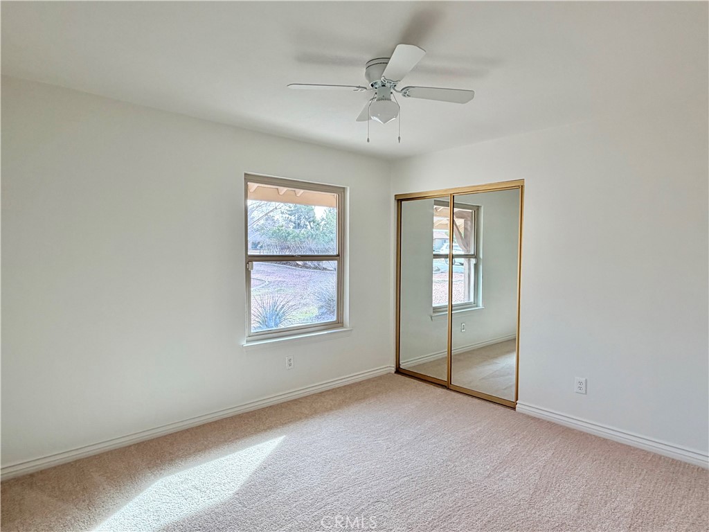 14840 Pamlico Road Apple Valley, CA 92307 - Photo 29 of 39 an empty room with chandelier fan and windows
