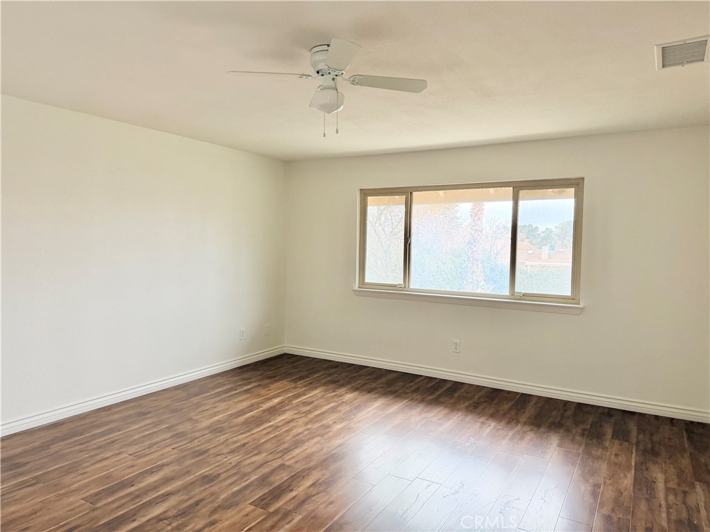 14840 Pamlico Road Apple Valley, CA 92307 - Photo 31 of 39 an empty room with wooden floor and windows
