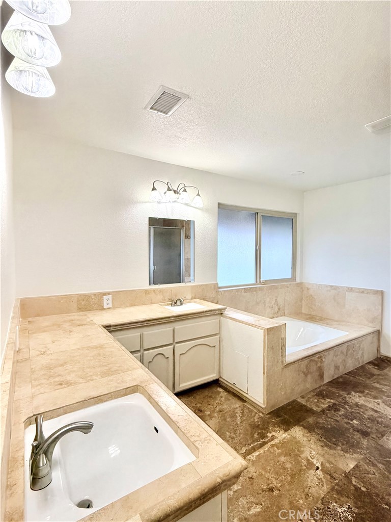 14840 Pamlico Road Apple Valley, CA 92307 - Photo 33 of 39 a spacious bathroom with a tub sink and mirror