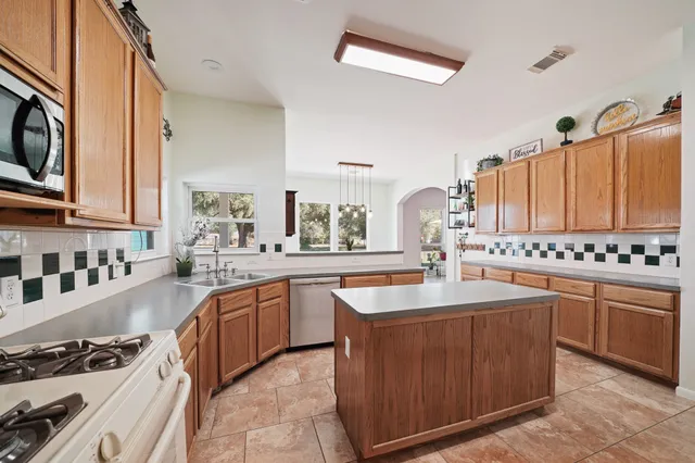 a kitchen with stainless steel appliances granite countertop a sink stove and cabinets