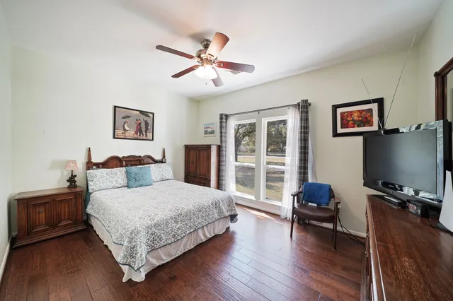 a bedroom with a bed window and a flat screen tv