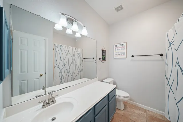 a bathroom with a sink vanity mirror and toilet