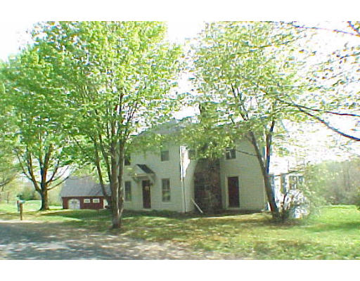 a view of a yard in front of a house with a tree
