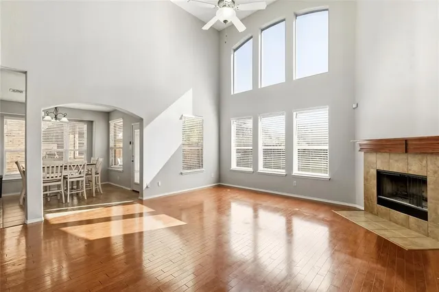 a view of an empty room with wooden floor and a fireplace