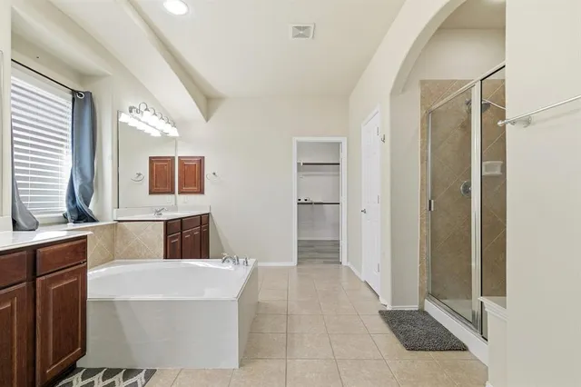 a bathroom with a tub shower and sink