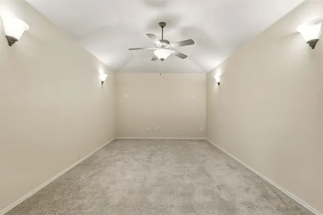 en empty room with ceiling fan and window