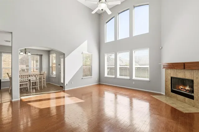 a view of an empty room with wooden floor and a fireplace